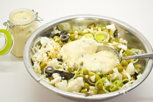 Добавляем в салат яйца, лук-порей, горошек, оливки и майонез