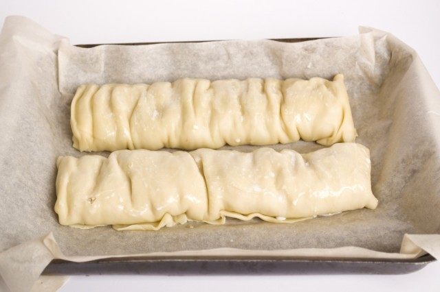 Nós cobrimos a assadeira com pergaminho e colocamos os strudels