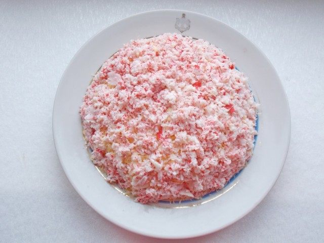 Слой 7. Выкладываем на салат натёртые крабовые палочки Слой 7. Выкладываем на салат натёртые крабовые палочки