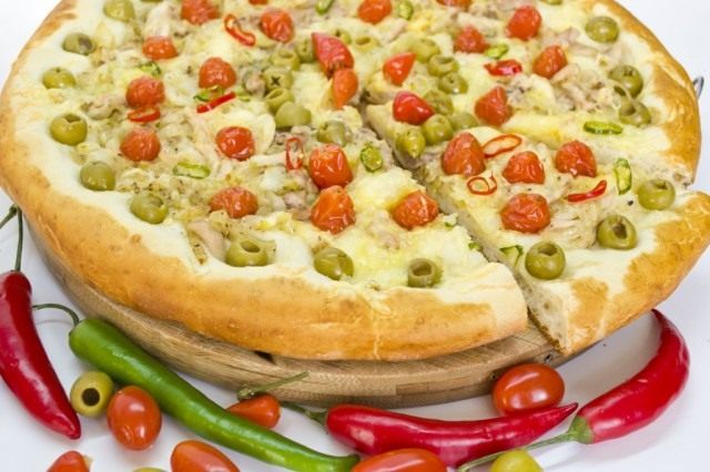 Готовую пиццу с курицей и томатами черри подаем горячей Готовую пиццу с курицей и томатами черри подаем горячей