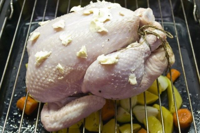 Запекаем курицу на решетке, поставленной на противень с овощами Запекаем курицу на решетке, поставленной на противень с овощами