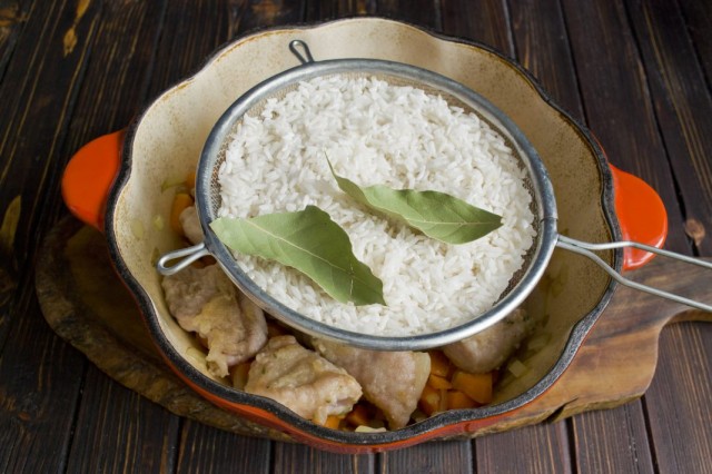 Выкладываем на мясо рис и лавровый лист Выкладываем на мясо рис и лавровый лист