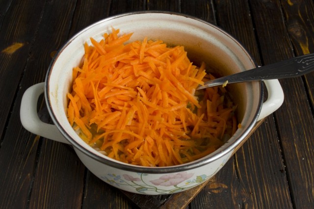 В кастрюлю с луком и грибами добавляем натёртую морковь