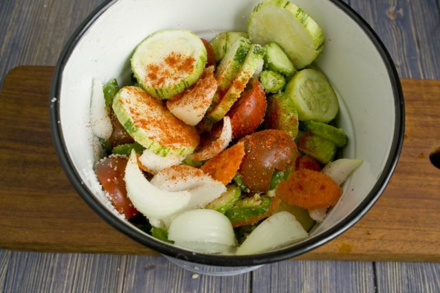 Собираем нарезанные овощи в эмалированную посуду, добавляем специи, соль и сахар. Перемешиваем и ставим под груз