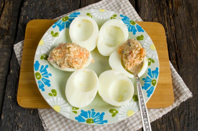 Наполняем начинкой из сельди, моркови и плавленного сыра половинки белков отваренных яиц Наполняем начинкой из сельди, моркови и плавленного сыра половинки белков отваренных яиц