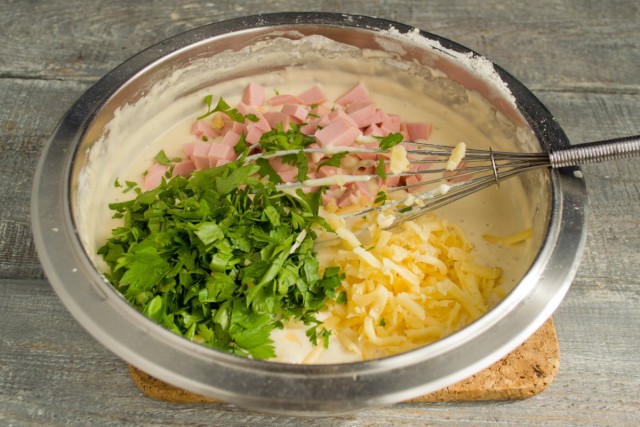 Кладём в миску с тестом колбаску, сыр и зелень