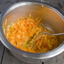 Бросаем измельченную морковь в кастрюлю и обжариваем 15 минут