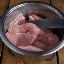 Кладём в кастрюлю крупные куски свиной вырезки Кладём в кастрюлю крупные куски свиной вырезки