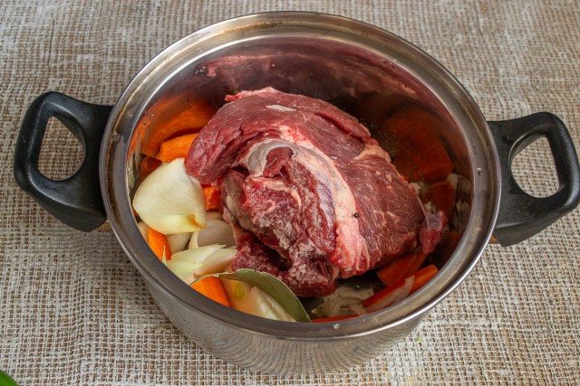 Кладём в кастрюлю лук, морковь, лавровый лист, горошины перца и кусок говядины Кладём в кастрюлю лук, морковь, лавровый лист, горошины перца и кусок говядины