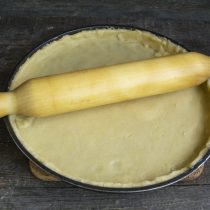 Раскатываем тесто, кладём в форму для пирога и подрезаем края 