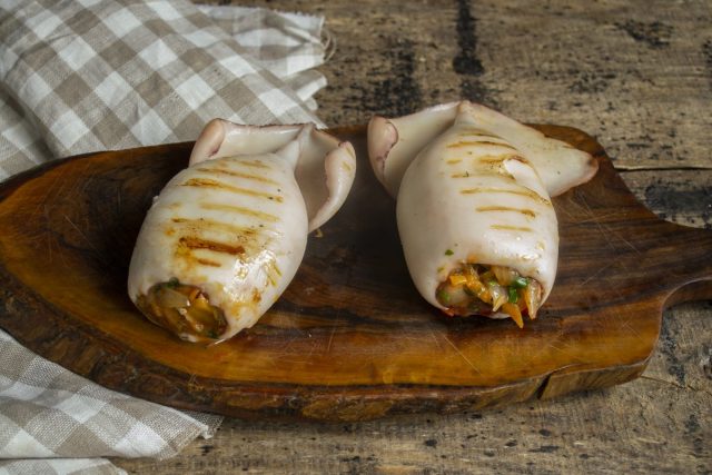 Подаём кальмары, фаршированные овощами и сыром, на стол тёплыми или холодными Подаём кальмары, фаршированные овощами и сыром, на стол тёплыми или холодными