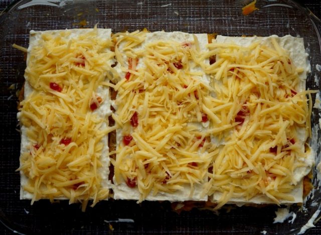 Верхний лист, смазанный соусом «Бешамель», посыпаем сыром и украшаем кетчупом