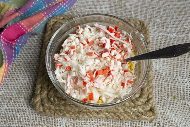Кладём в салатницу порезанные небольшими кубиками крабовые палочки Кладём в салатницу порезанные небольшими кубиками крабовые палочки