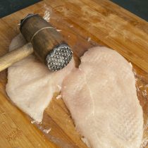 Накрываем мясо пищевой плёнкой, отбиваем молоточком Накрываем мясо пищевой плёнкой, отбиваем молоточком