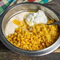 В миску выкладываем кукурузные зёрна, баночку измельченной кукурузы, добавляем сухие ингредиенты и сметану В миску выкладываем кукурузные зёрна, баночку измельченной кукурузы, добавляем сухие ингредиенты и сметану