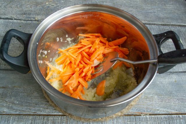 Добавляем измельченную морковку в кастрюлю, обжариваем 7 минут