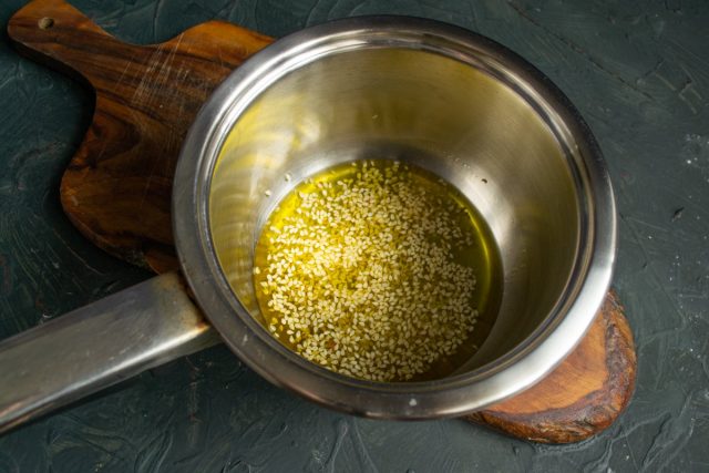 В сотейник наливаем оливковое или кунжутное масло, насыпаем семена кунжута и нагреваем