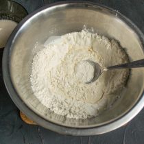 Вливаем молоко с дрожжами в миску с просеянной мукой, перемешиваем Вливаем молоко с дрожжами в миску с просеянной мукой, перемешиваем
