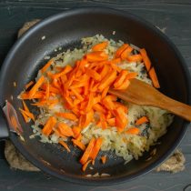 Добавляем морковку, обжариваем её вместе с луком ещё несколько минут