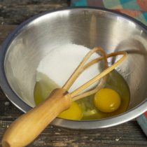 Смешиваем в миске свежие куриные яйца и сахар, добавляем щепотку соли Смешиваем в миске свежие куриные яйца и сахар, добавляем щепотку соли