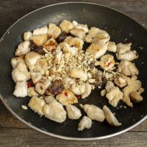 Добавляем в сковороду рубленые орехи, по вкусу солим, перчим Добавляем в сковороду рубленые орехи, по вкусу солим, перчим