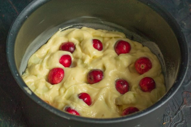 Выкладываем тесто с яблоками в форму, раскладываем сверху свежую клюкву 