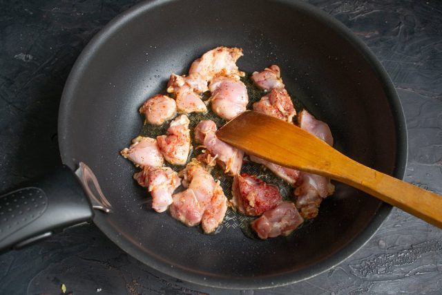 В разогретое масло кладём приправленные кусочки курицы, жарим на сильном огне В разогретое масло кладём приправленные кусочки курицы, жарим на сильном огне