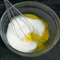 Смешиваем одно целое яйцо, желток, сахарный песок и щепотку соли, взбиваем ингредиенты венчиком