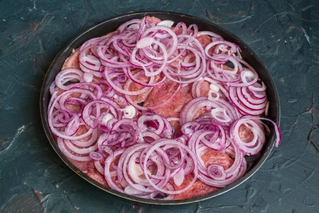 Выкладываем мясо в форму в один слой, на мясо кладём луковые кольца Выкладываем мясо в форму в один слой, на мясо кладём луковые кольца