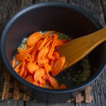 Добавляем морковь, увеличиваем нагрев и жарим 5-7 минут