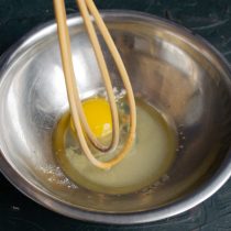 Разбиваем куриные яйца в миску, добавляем соль и сахарный песок, взбиваем венчиком