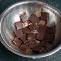 Плитку горького шоколада ломаем мелко, кладём в миску и ставим на водяную баню