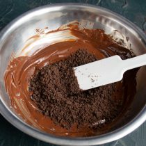Снимаем растопленный шоколад с водяной бани, добавляем крошки печенья Снимаем растопленный шоколад с водяной бани, добавляем крошки печенья