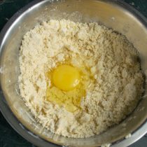 Растираем масло с мукой, разбиваем куриное яйцо, наливаем ложку холодной воды Растираем масло с мукой, разбиваем куриное яйцо, наливаем ложку холодной воды