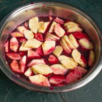 Яблоки режем тонкими ломтиками, кладём в виноградный сок