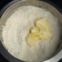 Кладём в миску с мучной смесью размягченное сливочное масло Кладём в миску с мучной смесью размягченное сливочное масло