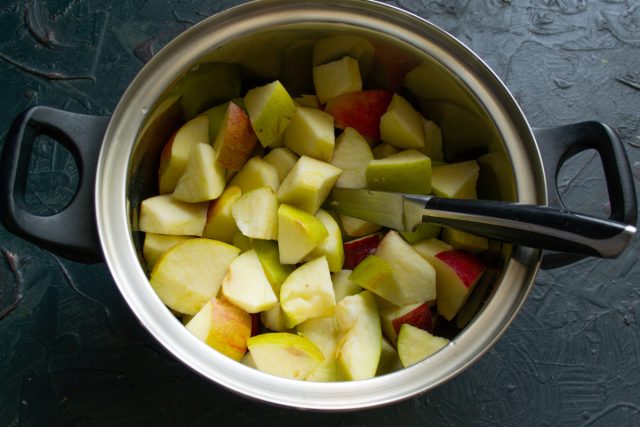Нарезанные яблоки кладём в кастрюлю, вливаем 1/2 стакана воды