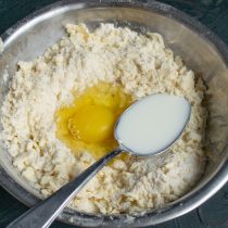 Добавляем куриное яйцо, холодную воду, ванильный экстракт и щепотку мелкой соли, замешиваем тесто
