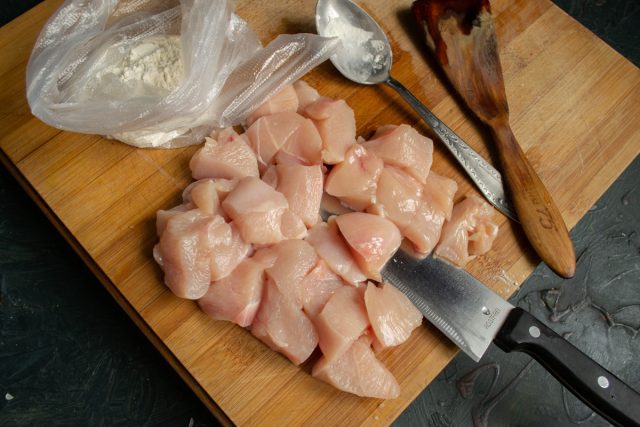 Нарезаем филе куриной грудки кусочками размером 2х2 сантиметра поперек волокон Нарезаем филе куриной грудки кусочками размером 2х2 сантиметра поперек волокон