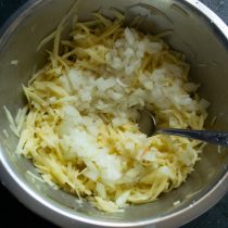 Отжимаем тёртый картофель, добавляем нарезанный лук