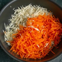 Добавляем тёртую морковь, солим, перемешиваем и тушим на среднем огне 