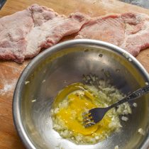 Разбиваем яйца в мисочку, добавляем нарезанный репчатый лук и соль, смешиваем