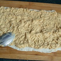 На лаваш выкладываем пасту из сыра и яиц, размазываем ровным слоем