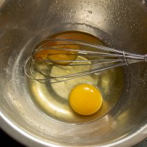Разбиваем куриные яйца в миску, добавляем соль и сахар, смешиваем венчиком