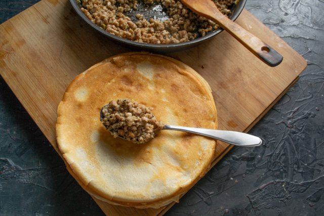 На середину блина кладём обжаренный фарш с луком и сворачиваем конверты-трубочки На середину блина кладём обжаренный фарш с луком и сворачиваем конверты-трубочки
