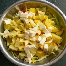 Нарезаем крупными кубиками сыр, добавляем к нарезанным овощам