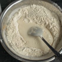 Добавляем аквафабу с сахаром и маслом небольшими порциями, замешиваем тесто