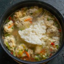 Через 10 минут кладём в суп готовый рис. Аккуратно перемешиваем