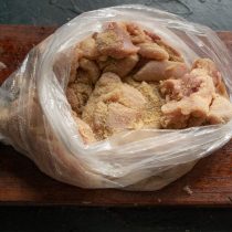 В пакет насыпаем молотые сухари, кладем нарезанную курицу и трясем, чтобы панировка прилипла к мяса