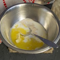 В столовой ложке молока растворяем соль и сахар, вливаем в миску. Добавляем растопленное, но не горячее сливочное масло